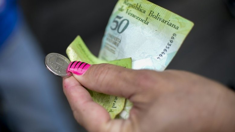 Diante de escassez de dinheiro, venezuelanos pagam para comprar notas