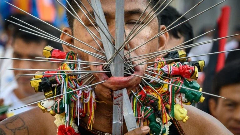 Festival vegetariano da perfuração da pele para se purificar na Tailândia