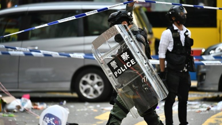 Policial de Hong Kong atira em um manifestante encapuzado