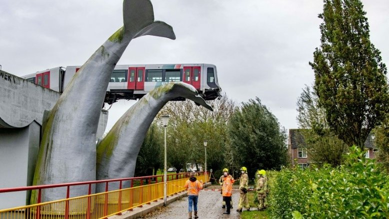 Cauda de escultura de baleia evita que um vagão de metrô caia na água