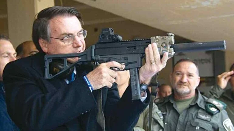 NA MIRA Bolsonaro empunha uma submetralhadora: pandemia serviu de pretexto para relaxar o controle de armamentos