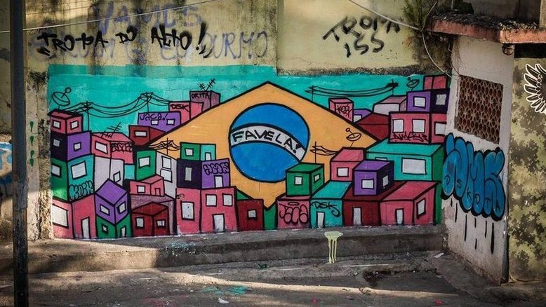 Jovens fazem grafite para cobrir buracos de tiros no Jacarezinho, no Rio
