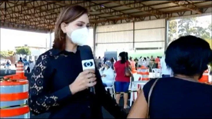 Repórter chama atenção de mulher que passou em frente às câmeras durante reportagem
