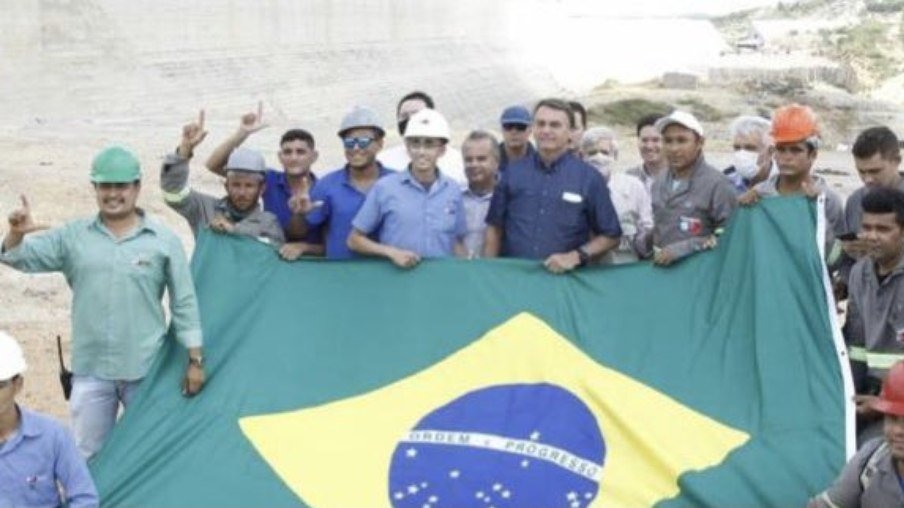 Trabalhadores fazem o 'L' de Lula com as mãos em foto ao lado de Bolsonaro