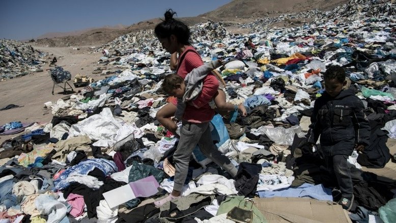 (Arquivo) Imigrante venezuelana busca roupas para ela e seus filhos em um lixão em Alto Hospicio, na região de Iquique, no Chile, em 26 de setembro de 2021 - AFP