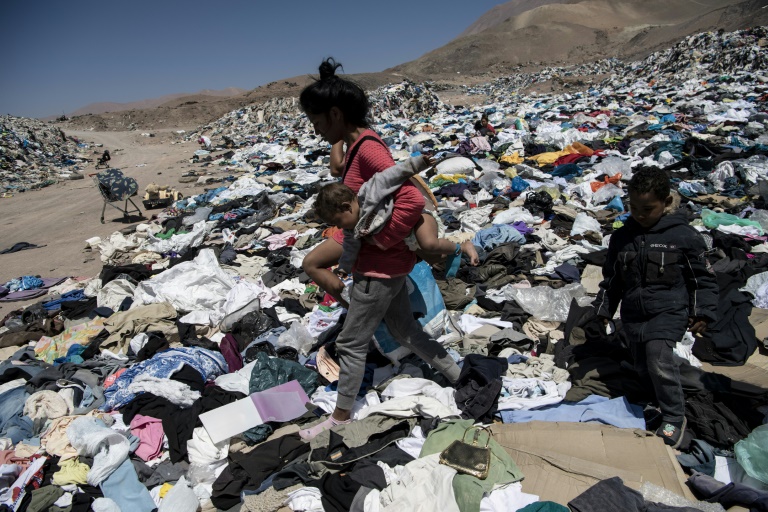 (Arquivo) Imigrante venezuelana busca roupas para ela e seus filhos em um lixão em Alto Hospicio, na região de Iquique, no Chile, em 26 de setembro de 2021 - AFP