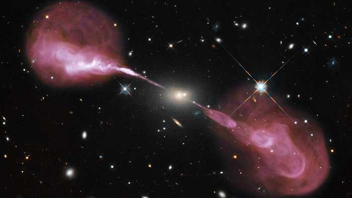 Esses jatos espetaculares são alimentados pela energia gravitacional de um buraco negro supermassivo no núcleo da galáxia elíptica de Hércules. A cerca de dois bilhões de anos-luz da Terra, a galáxia é aproximadamente 1.000 vezes mais massiva que a Via Láctea e abriga um buraco negro central de 2,5 bilhões de massa solar, 1.000 vezes mais massivo que o buraco negro da Via Láctea. Emitindo quase um bilhão de vezes mais energia em comprimentos de onda de rádio do que o nosso Sol, a galáxia é uma das fontes de rádio extragalácticas mais brilhantes em todo o céu