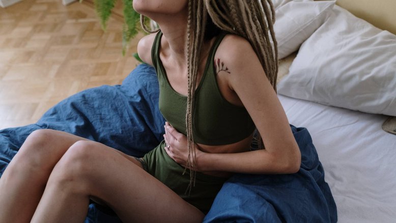mulher com cólicas menstruais, maneiras de amenizar desconfortos menstruais