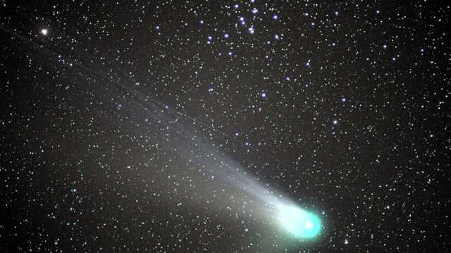 O brilhante cometa C/2001 Q4 (NEAT) mostra muitos detalhes de sua cauda, enquanto ao longe o aglomerado aberto Beehive, M44, revela suas estrelas. O cometa desapareceu no limite da visibilidade sem ajuda em 2004. O M44 permanecerá um aglomerado estelar impressionante na direção da Constelação de Câncer indefinidamente