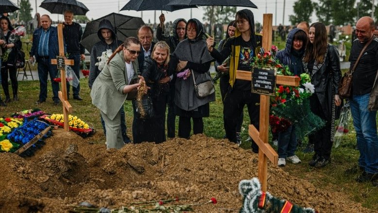 Pessoas participam do funeral de Olexandr Haponchev, de 47 anos, um soldado ucraniano morto durante a invasão russa da Ucrânia, na seção militar do cemitério 18 de Kharkiv, em Bezlioudivka, leste da Ucrânia, em 21 de maio de 2022