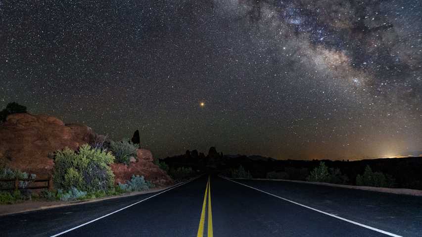 Essa luz no fim da estrada é Marte. O fenômeno que deixou nosso vizinho brilhante desse jeito ocorreu em maio de 2018. O planeta esteve a cerca de 180 graus do Sol e mais próximo da Terra. Marte também se aproximou do ponto mais perto do Sol em sua órbita elíptica, assim como a Terra se move quase entre ele e o Sol – um alinhamento conhecido como oposição periélica. Nesta imagem, o planeta vermelho foi capturado a partir de um trecho de estrada no Parque Nacional Arches, perto da cidade de Moab, no Estado de Utah (EUA)