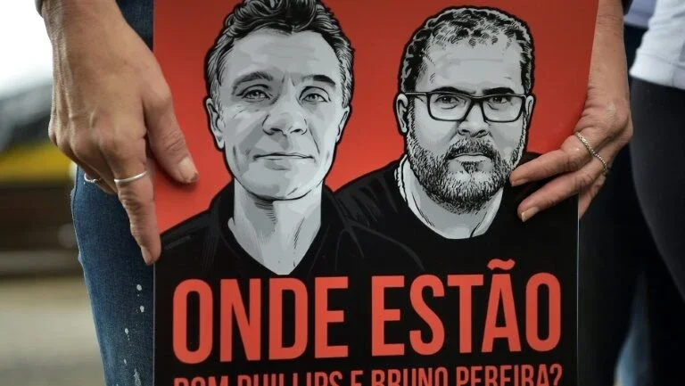 Um manifestante segura uma faixa com o Dom Philipps e Bruno Pereira lendo “Onde estão eles?” na praia de Copacabana, no Rio de Janeiro, em 12 de junho de 2022. - AFP