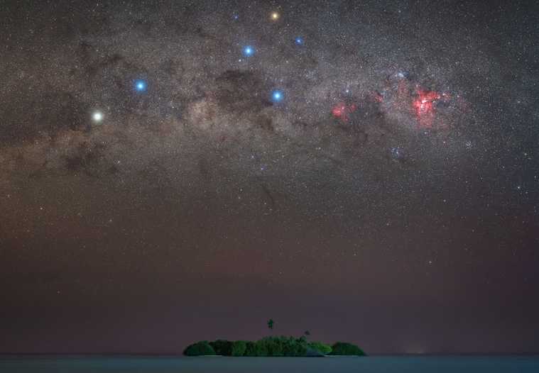 A parte mais ao sul da Via Láctea contém não apenas as estrelas do Cruzeiro do Sul, mas o sistema estelar mais próximo do nosso Sol - Alpha Centauri. O Cruzeiro do Sul é encimado pela estrela brilhante e amarelada Gamma Crucis. Uma linha de Gamma Crucis através da estrela azul na parte inferior da cruz, Acrux, aponta para o pólo celeste sul, localizado logo acima da pequena ilha na foto. Essa ilha é Madivaru, das Maldivas no Oceano Índico. Contra a fraca luz estelar da Via Láctea, a escura Nebulosa do Saco de Carvão fica à esquerda da cruz, enquanto mais à esquerda ao longo da Via Láctea estão as estrelas brilhantes Alpha Centauri (esquerda) e Beta Centauri (Hadar). Alpha Centauri A, uma estrela parecida com o Sol que ancora um sistema de três estrelas com exoplanetas, está a apenas 4,3 anos-luz de distância