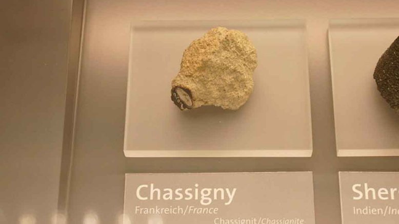 Fragmento do meteorito Chassigny no Museu de Ciência de Viena. Crédito: Valugi/Wikimedia Commons