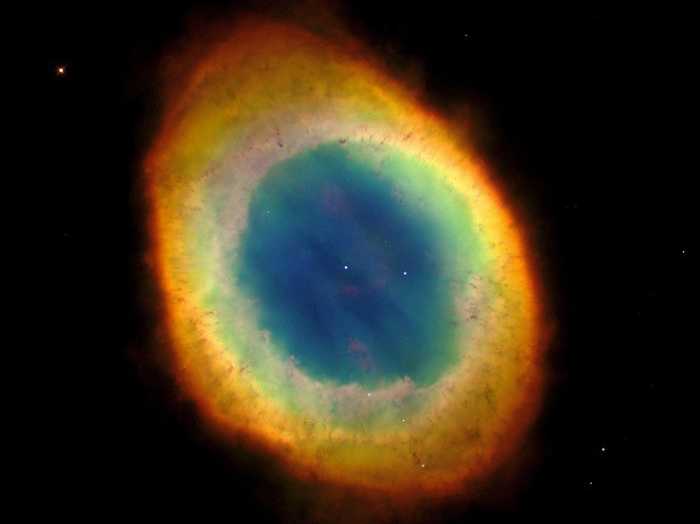 A Nebulosa do Anel (M57) é uma estrela moribunda que jogou fora parte de seu material externo, há milhares de anos. Ela está situada a 2.000 anos-luz de distância da Terra, na direção da Constelação da Lira. Nesta imagem, feita pelo Telescópio Espacial Hubble da NASA/ESA, vemos o gás lançado pela estrela central que flutua em meio a uma névoa azul, gasosa e quente. A nebulosa tem cerca de um ano-luz de diâmetro