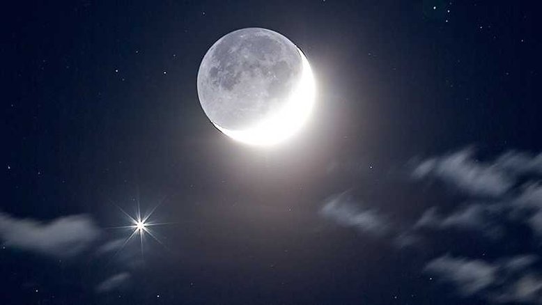 Os dois objetos mais brilhantes no céu noturno pareciam passar um pelo outro nesta imagem, feita em maio de 2007, perto da cidade de Quebec, no Canadá. A Lua e o planeta Vênus estavam visíveis na mesma parte do céu e, no momento mais próximo, estavam a menos de um grau de distância. Vênus aparece no canto inferior esquerdo, com pináculos reluzentes que são picos de difração causados pela própria câmera. A imagem é tão clara que é possível até ver algumas crateras da Lua. Embora a Lua passe por Vênus uma vez por mês, uma aproximação dessa magnitude e visível no céu noturno é mais rara