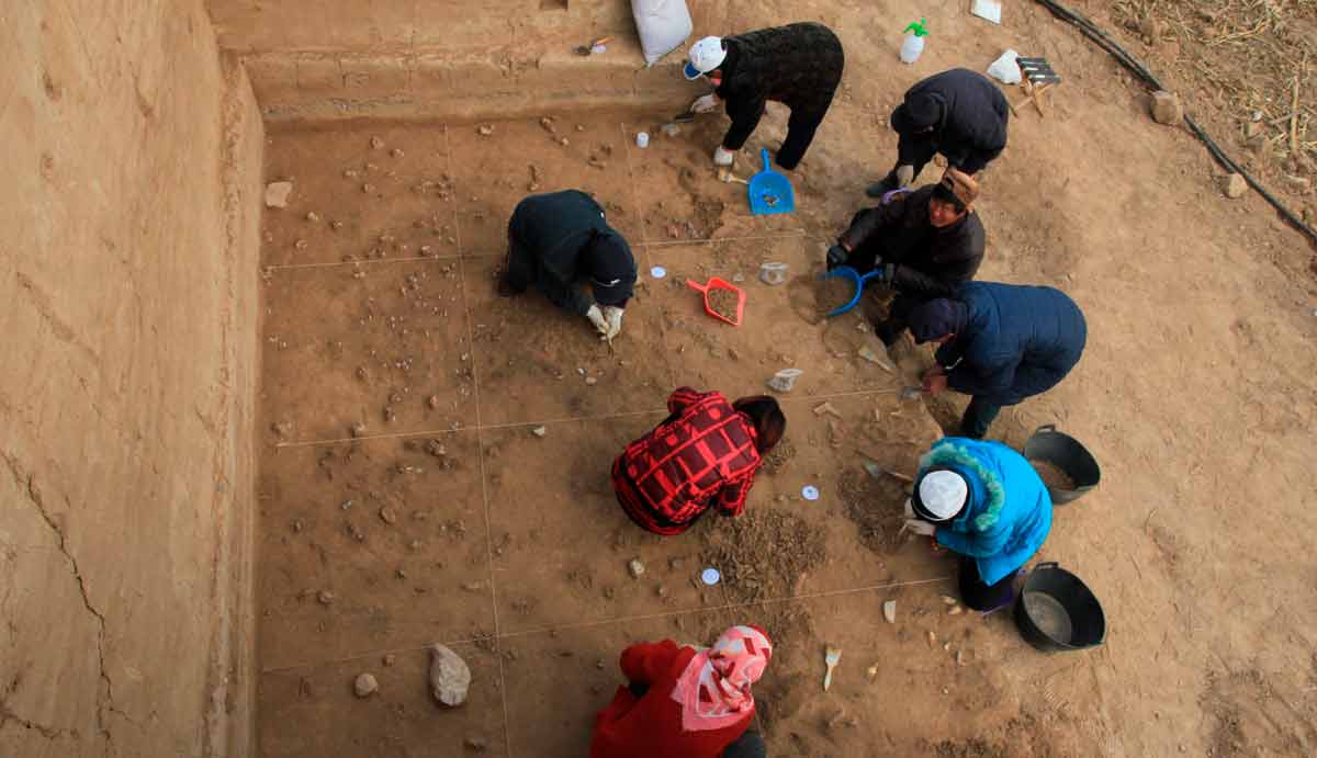 Arqueólogos escavam a superfície bem preservada no sítio de Xiamabei, nordeste da China, mostrando ferramentas de pedra, fósseis, pigmentos ocre e vermelho. Crédito: Fa-Gang Wang