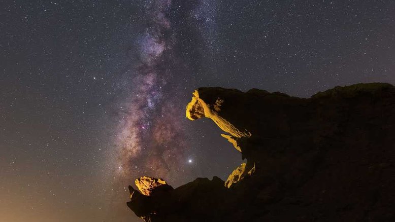 O maior planeta do nosso Sistema Solar é também um dos mais brilhantes no céu noturno, sendo superado apenas por Vênus em brilho aparente. A imagem em destaque foi tirada em julho de 2019, no Golfo Pérsico, e mostra Júpiter logo à direita da faixa quase vertical do disco central da Via Láctea, a nossa galáxia. As formações rochosas parecem com mandíbulas de um monstro pronto para engolir o gigante joviano. Quando você olhar para Júpiter, lembre-se de seus números colossais: ele é orbitado por 79 luas já identificadas e tem uma massa correspondente a aproximadamente 2,5 vezes a massa de todos os planetas do Sistema Solar combinados