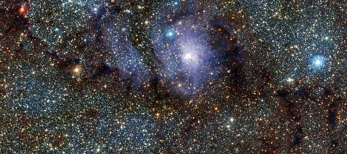 Esta imagem mostra a visão infravermelha da região de formação estelar Messier 8, muitas vezes chamada de Nebulosa da Lagoa. Ela foi capturada pelo telescópio VISTA, no Observatório do Paranal, no Chile. A composição foi criada a partir de imagens que pertencem a um grande levantamento sobre as partes centrais da Via Láctea. A Nebulosa da Lagoa, também denominada NGC 6523 e NGC 6530, fica a 5 mil anos-luz de distância, na direção da Constelação de Sagitário