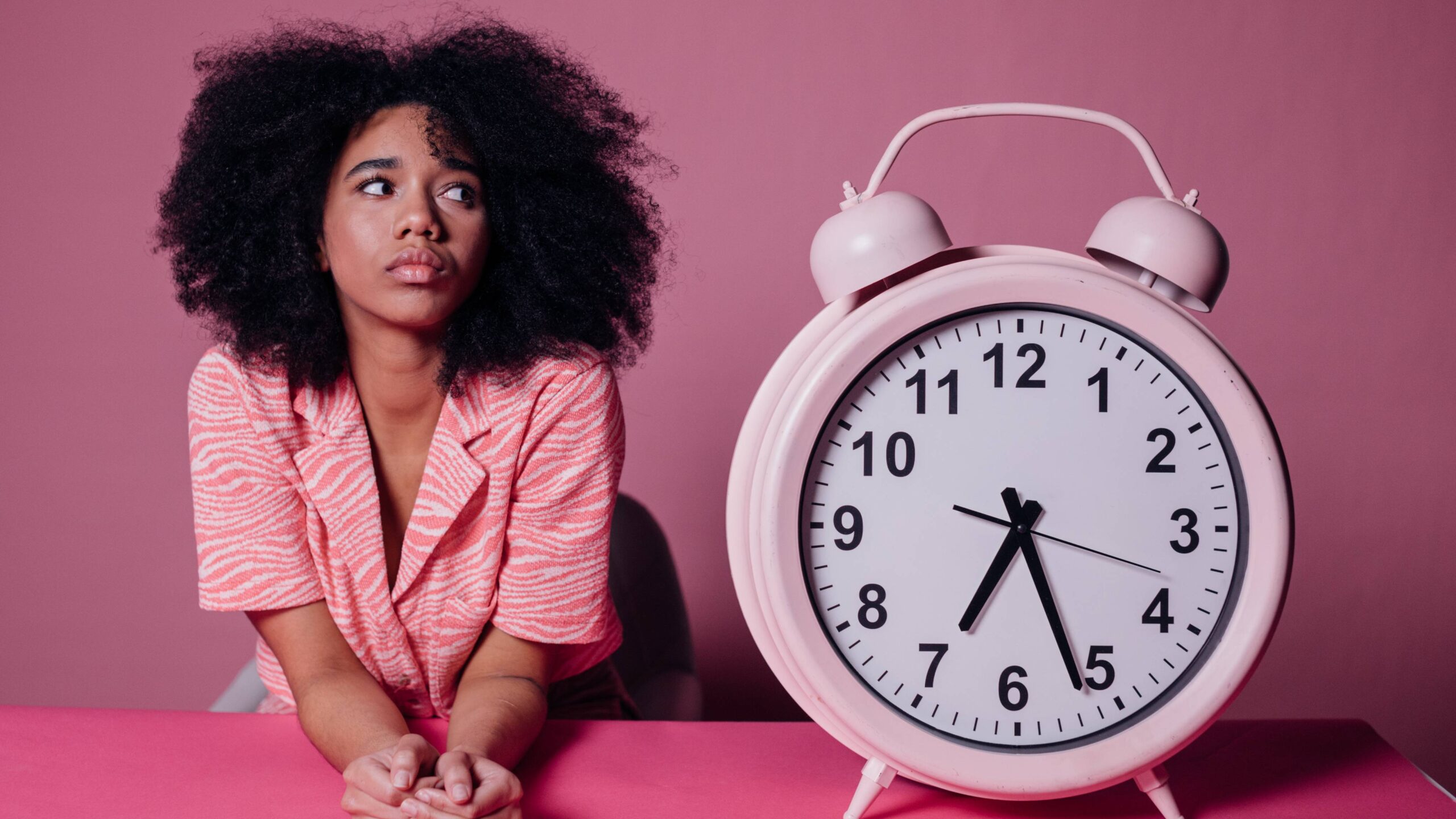 mulher ao lado de um relógio, evitar a procrastinação, síndrome da mulher com pressa