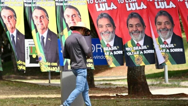 Toalhas com as imagens dos candidatos Jair Bolsonaro e Luiz Inácio Lula da Silva à venda em rua de Brasília - AFP