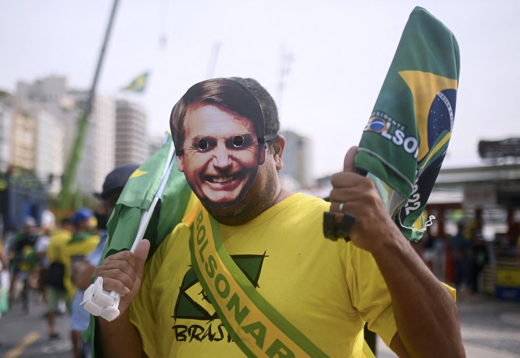 A supporter of Brazilian President Jair Bolsonaro wearing a mask of the president arrives for a military parade to mark Brazil's 200th anniversary of independence, close to Copacabana Beach in Rio de Janeiro, on September 7, 2022. (Photo by ANDRE BORGES / AFP)