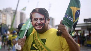 A supporter of Brazilian President Jair Bolsonaro wearing a mask of the president arrives for a military parade to mark Brazil's 200th anniversary of independence, close to Copacabana Beach in Rio de Janeiro, on September 7, 2022. (Photo by ANDRE BORGES / AFP)