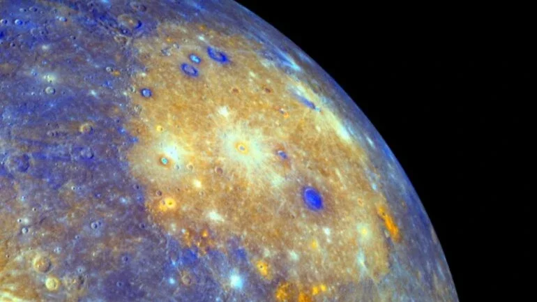 A extensa bacia Caloris, em Mercúrio, é uma das maiores bacias de impacto do Sistema Solar. Criada pelo choque de um grande corpo do tamanho de um asteroide, a bacia se estende por cerca de 1,5 mil km e é vista em tons amarelados neste mosaico de cores. As manchas alaranjadas ao redor do perímetro da bacia são consideradas aberturas vulcânicas, uma nova evidência de que as planícies lisas de Mercúrio são, de fato, fluxos de lava