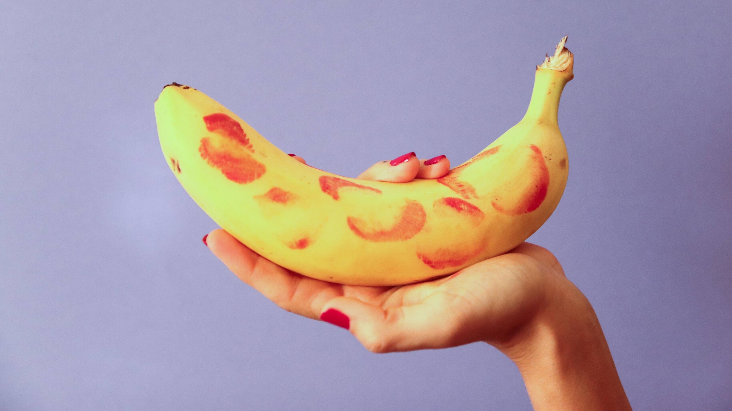mão feminina segurando banana com cascas de batom, dicas 69