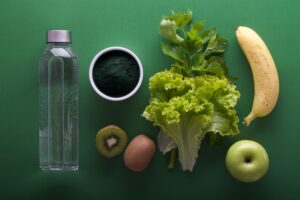 ingredientes para suco verde em uma mesa verde, perder gordura abdominal