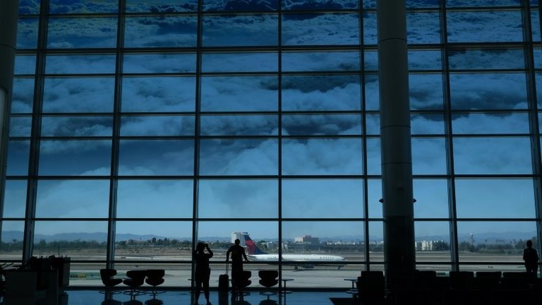 Passageiros olham para um avião no terminal internacional do aeroporto de Los Angeles em 10 de agosto de 2022. - AFP/Arquivos