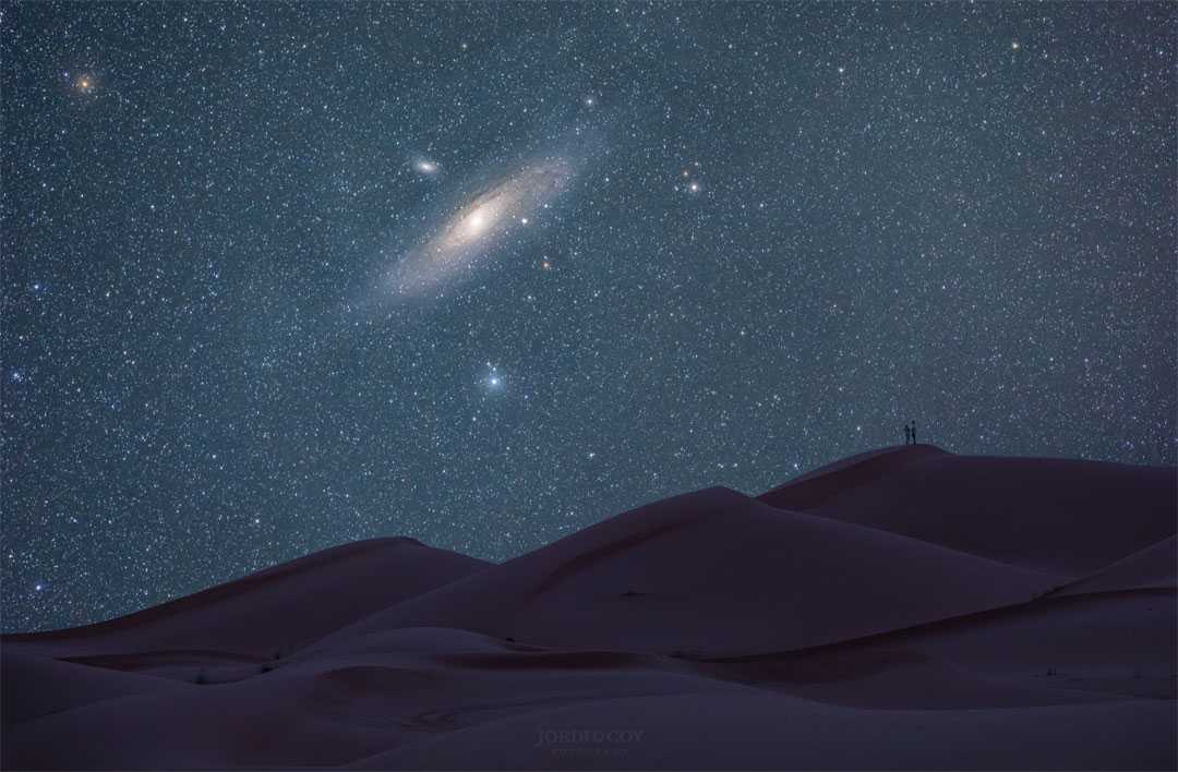 Qual é a coisa mais antiga que você pode ver a olho nu? A 2,5 milhões de anos-luz de distância está a galáxia de Andrômeda, na direção da Constelação de Andrômeda. A maioria dos outros habitantes aparentes do céu noturno - estrelas, aglomerados e nebulosas - aparecem como eram há apenas algumas centenas ou milhares de anos, pois estão dentro da Via Láctea, a nossa galáxia. Também conhecida como M31, a galáxia de Andrômeda domina o centro desta imagem, tirada no deserto do Saara, no Marrocos, em julho deste ano. M110, uma galáxia satélite de Andrômeda, está visível logo acima e à esquerda do núcleo de M31. Dados recentes indicam que a Via Láctea colidirá com Andrômeda em alguns bilhões de anos