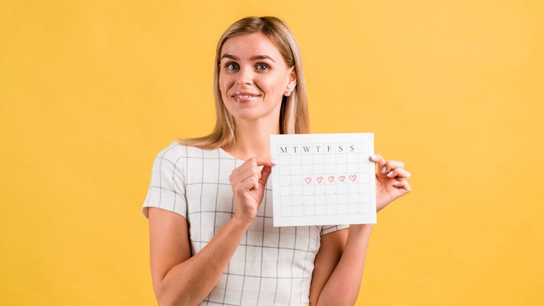 mulher segurando calendário, ciclo menstrual