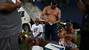 Caminhoneiros compartilham churrasco e cerveja em acampamento durante um bloqueio na rodovia Via Dutra BR-116 entre Rio de Janeiro e São Paulo, perto de Barra Mansa, no estado do Rio de Janeiro, em 31 de outubro de 2022 - AFP