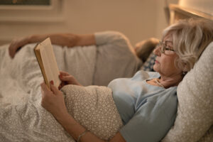 mulher idosa lendo livro, higiene do sono