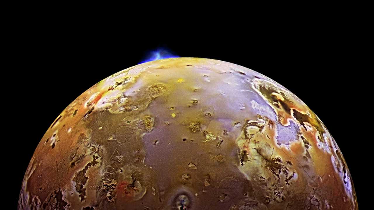 A espaçonave Galileo, da Nasa, capturou esta imagem de uma erupção vulcânica em Io, uma das luas de Júpiter. Io é o mundo vulcânico mais ativo do Sistema Solar, graças à forte influência gravitacional de Júpiter, bem como de outras de suas luas Ganimedes e Europa. As forças de maré extremas geram uma tremenda quantidade de calor dentro de Io, mantendo grande parte de sua crosta subterrânea na forma líquida, a todo tempo buscando uma rota de fuga disponível em direção à superfície para aliviar a pressão. Centenas de vulcões enormes cobrem a superfície de Io, com fontes de lava em erupção que atingem dezenas de quilômetros de altura