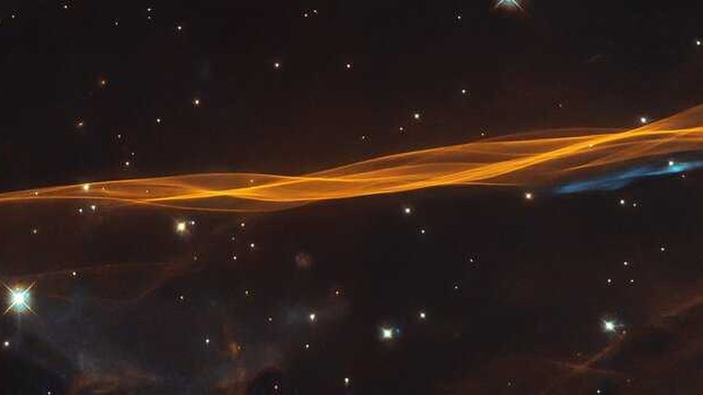 Embora pareça um véu delicado e leve, esta imagem do Telescópio Espacial Hubble mostra uma pequena parte da onda de explosão da supernova Cygnus, localizada a cerca de 2,4 mil anos-luz de distância. O nome do remanescente deriva do fato de ela estar na boreal Constelação do Cisne. A supernova destruiu uma estrela moribunda, cerca de 20 vezes mais massiva que o nosso Sol, entre 10 mil e 20 mil anos atrás. Desde então, o remanescente se expandiu 60 anos-luz e continua a se expandir a cerca de 350 quilômetros por segundo. A interação do material ejetado e do material interestelar de baixa densidade forma a estrutura semelhante a um véu vista nesta imagem