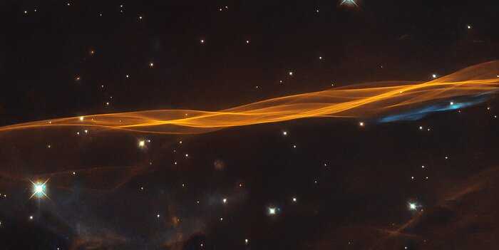 Embora pareça um véu delicado e leve, esta imagem do Telescópio Espacial Hubble mostra uma pequena parte da onda de explosão da supernova Cygnus, localizada a cerca de 2,4 mil anos-luz de distância. O nome do remanescente deriva do fato de ela estar na boreal Constelação do Cisne. A supernova destruiu uma estrela moribunda, cerca de 20 vezes mais massiva que o nosso Sol, entre 10 mil e 20 mil anos atrás. Desde então, o remanescente se expandiu 60 anos-luz e continua a se expandir a cerca de 350 quilômetros por segundo. A interação do material ejetado e do material interestelar de baixa densidade forma a estrutura semelhante a um véu vista nesta imagem
