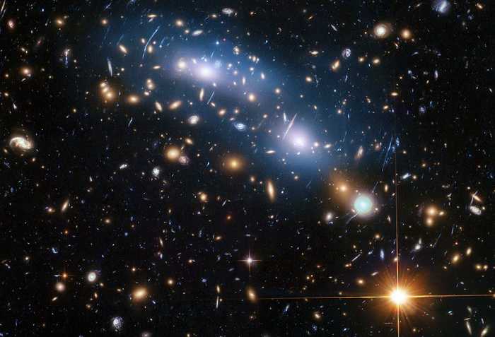 O aglomerado de galáxias MACS J0416 é um dos seis aglomerados estudados pelo programa Hubble Frontier Fields, que produziu as imagens mais profundas de lentes gravitacionais, com a ajuda do Telescópio Espacial Hubble. Os cientistas usaram a luz intra-aglomerado (visível em azul), que é produzida por estrelas que não fazem parte de nenhuma galáxia, para estudar a distribuição da matéria escura dentro do aglomerado. MACS J0416 está a uma distância de aproximadamente 4 bilhões de anos-luz, na direção da Constelação de Eridanus