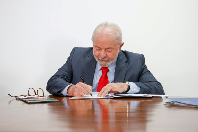 O presidente Luiz Inácio Lula da Silva assina um documento con novas medidas econômicas em Brasília, em 12 de janeiro de 2023 - AFP