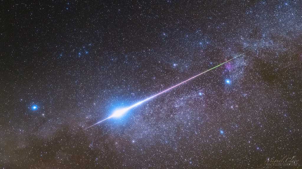 Atravessando a atmosfera da Terra a 60 quilômetros por segundo, este meteoro Perseida cruza a faixa estrelada da Via Láctea. Visto no céu de Portugal, em agosto de 2021, ele se move da direita para a esquerda da imagem. Sua trilha colorida começa perto de Deneb, a estrela Alfa da Constelação do Cisne, e termina perto de Altair, a estrela Alfa da Constelação da Águia. Assim, o meteoro ofusca brevemente duas das estrelas mais brilhantes da noite no planeta Terra. O brilho esverdeado inicial de sua trilha é típico dos meteoros da chuva de Perseidas. Esses meteoros são detritos que resultam do rastro do cometa Swift-Tuttle. Movendo-se rápido o suficiente, eles geram essa característica emissão verde de oxigênio atômico, em altitudes de cem quilômetros ou mais, antes de se vaporizar em um flash incandescente