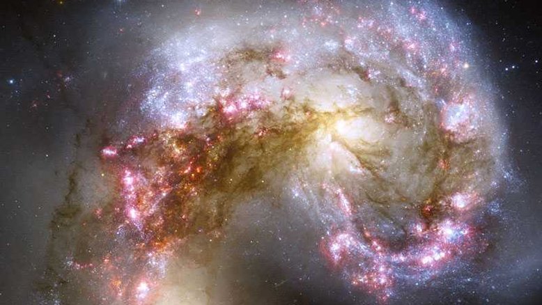 As galáxias catalogadas como NGC 4038 e NGC 4039 parecem se enfrentar, na Constelação do Corvo, a cerca de 65 milhões de anos-luz de distância. No entanto, quando duas galáxias colidem, as suas estrelas geralmente não fazem o mesmo. Isso ocorre porque as galáxias são preenchidas principalmente por espaços vazios, de forma que as estrelas ocupam apenas uma pequena parcela do seu espaço. Durante o processo de colisão, que pode durar centenas de milhões de anos, no entanto, uma galáxia pode alterar a outra gravitacionalmente. No encontro acima, os pilares de poeira escura marcam nuvens moleculares massivas que estão sendo comprimidas, gerando o rápido nascimento de milhões de estrelas