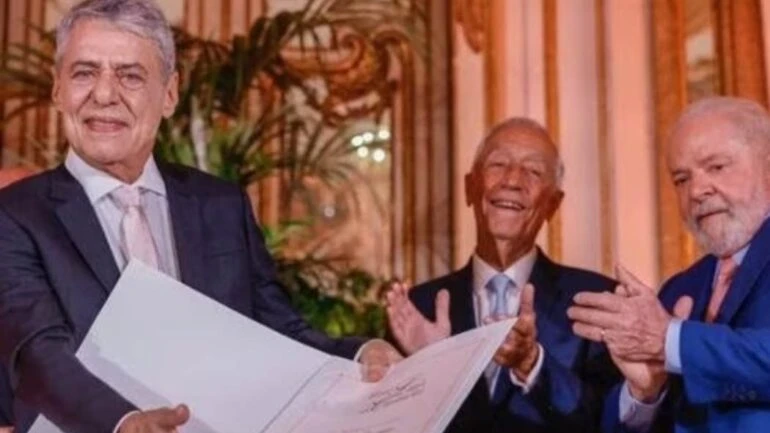 Chico Buarque discursa ao lado de Lula, no Prêmio Camões, em Portugal