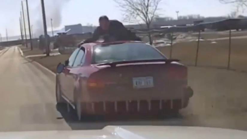 Vídeo: Policial se agarra no teto de carro durante perseguição nos EUA