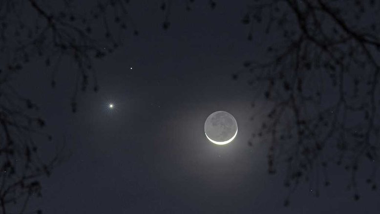 O brilhante planeta Vênus, batizado com o nome da deusa romana do amor, e Marte, homônimo do deus da guerra, juntaram-se à Lua Nova nesta paisagem celeste, registrada em fevereiro de 2015, em Charleston, Carolina do Sul, EUA. Nesta imagem, também é possível ver o brilho da Terra refletido na superfície escura da Lua, que recebe o nome de luz cinérea. Com o passar dos dias, a Lua foi a primeira a afastar-se, desfazendo a conjunção tripla, já que é o astro que mais rapidamente se movimenta no céu. Vênus aparece como Estrela Vespertina, brilhando, a Oeste, depois do pôr do Sol. O outro ponto que brilha, um pouco mais fraco e mais acima, é Marte