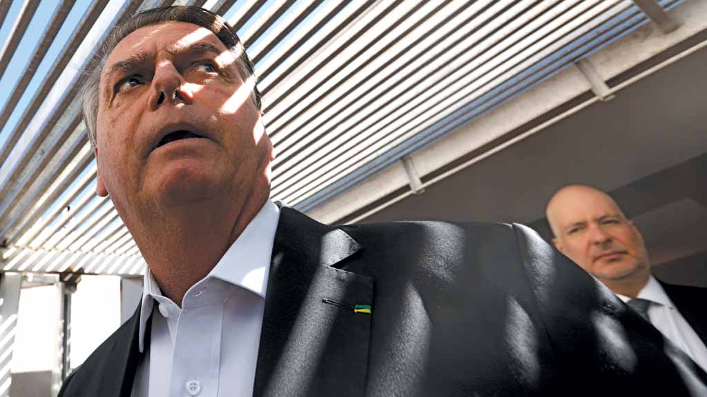 ACUADO Jair Bolsonaro fala com jornalistas em frente à sua casa em Brasília, após a operação da PF, na quarta-feira, 3: policiais confiscaram seu celular (Crédito:Cristiano Mariz)