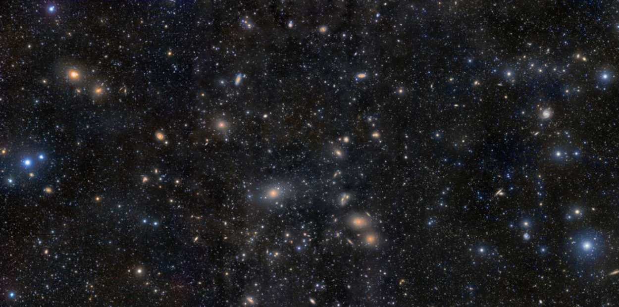 Há bem mais de mil membros conhecidos do Aglomerado de Virgem, o grande aglomerado de galáxias mais próximo ao Grupo Local, onde está a nossa Via Láctea. Nesta imagem, vê-se a região central do Aglomerado de Virgem. A galáxia elíptica gigante, M87, está logo abaixo e à esquerda do centro da imagem. À direita de M87 está a famosa Cadeia de Markarian, que também contém diversas galáxias. Muitos membros do aglomerado aparecem como pequenas manchas difusas. As galáxias do Aglomerado de Virgem estão a uma distância média de cerca de 48 milhões de anos-luz de distância, na direção da Constelação de Virgem