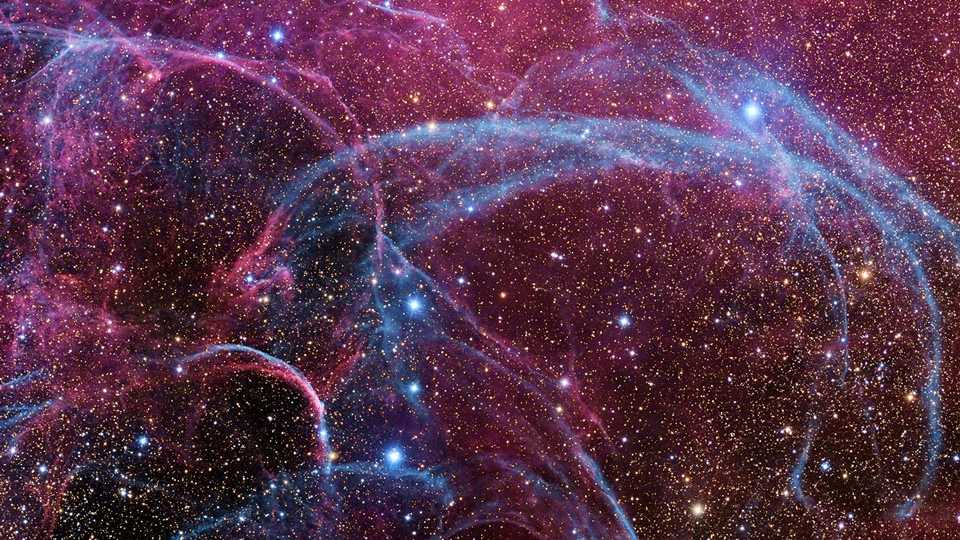 A cerca de 11 mil anos atrás, uma estrela na Constelação da Vela explodiu, criando um estranho ponto de luz brevemente visível no céu no planeta Terra. As camadas externas da estrela colidiram com o meio interestelar, gerando uma onda de choque visível até hoje. Em raios-X, vê-se uma onda de choque em expansão esférica. Nesta imagem, uma parte desse choque gigantesco aparece em luz visível. À medida que o gás se afasta da estrela detonada, ele decai e reage com o meio interestelar, produzindo luz em muitas cores e bandas de energia. No centro deste Remanescente de Supernova da Vela está um pulsar, uma estrela tão densa que gira mais de dez vezes em um único segundo