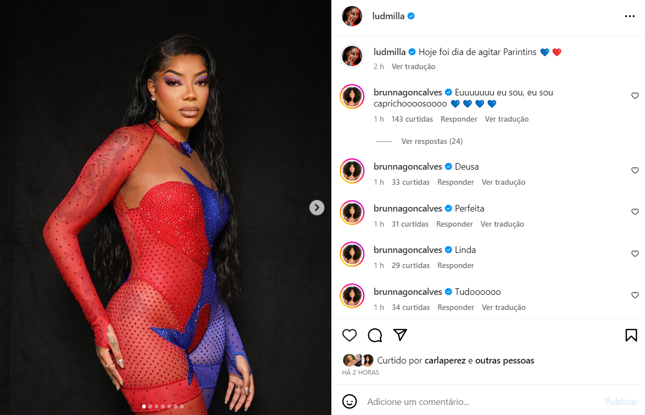 print da publicação de ludmilla no instagram. na foto, a cantora aparece vestindo um macacão que é metade azul e metade vermelho.