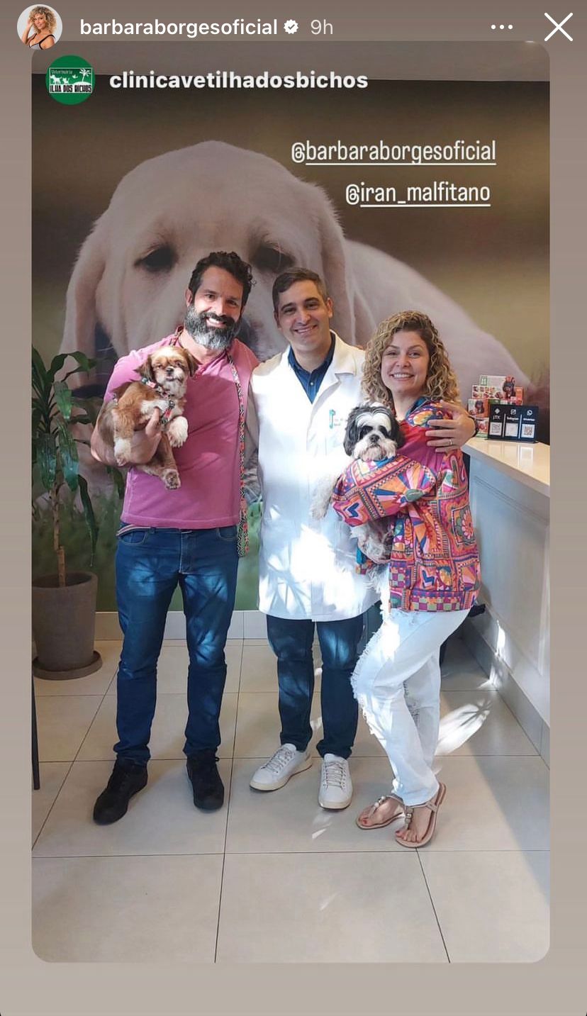 Bárbara Borges e Iran Malfitano em uma clina veterinária, ao lado de um médico e segurando um cachorro cada